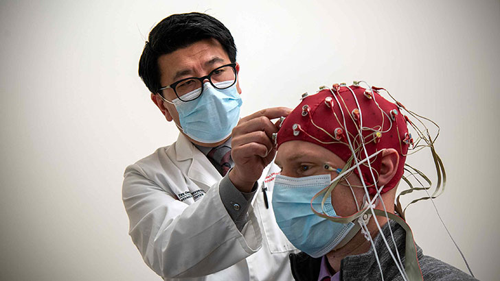 Dr. Phan with patient with headcap and wires attached for study