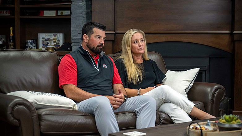 Coach Ryan Day and his wife sitting on leather couch